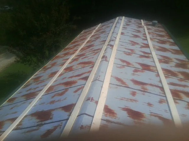 Rusted metal roof panels with new wood purlins before replacement — Storm Damage Roof Repair in Garwood by Roofing Brothers