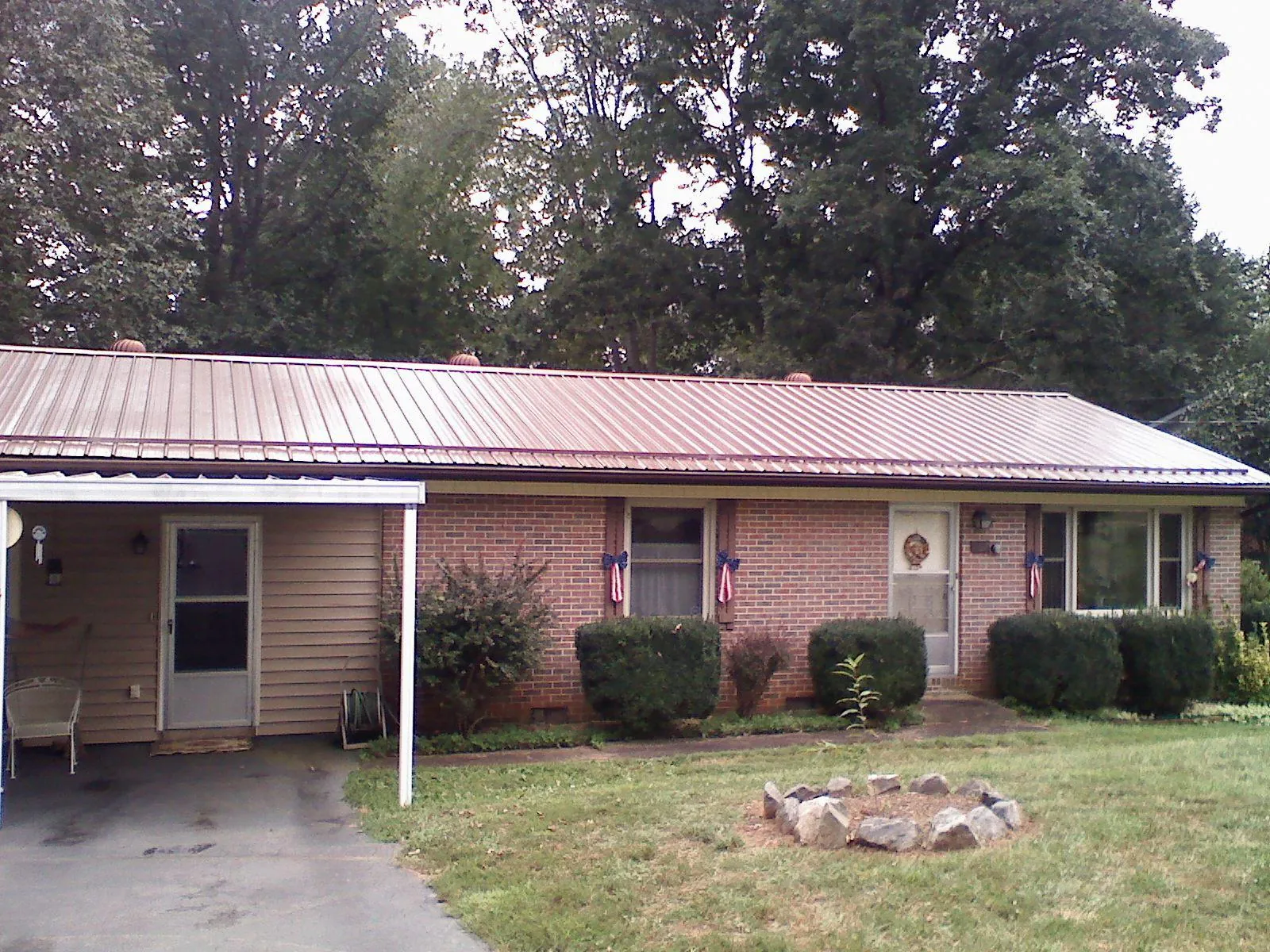 Bronze metal roof and carport on a brick ranch home — Roof Repair work by our crew in Garwood